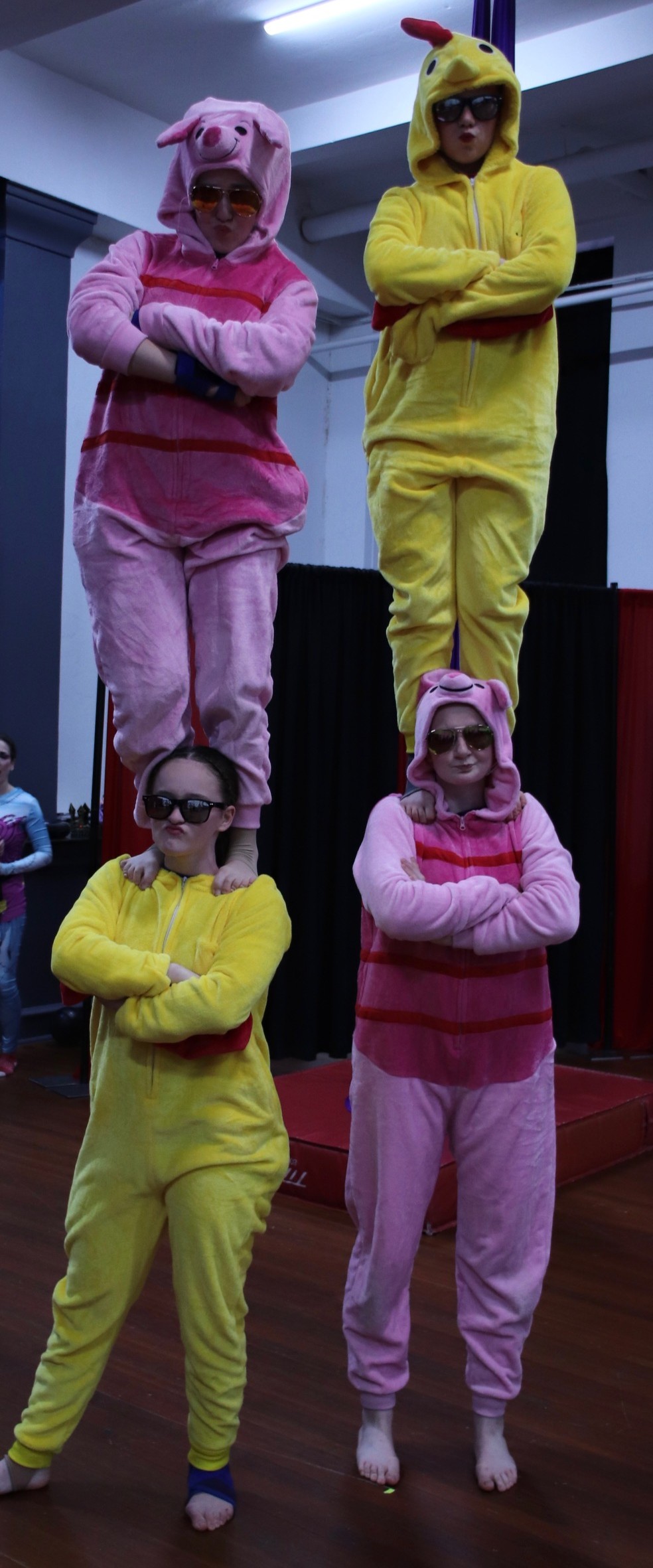 Sammie, Sylvie, Jael, and Lilah standing in two highs in pig and duck onesies